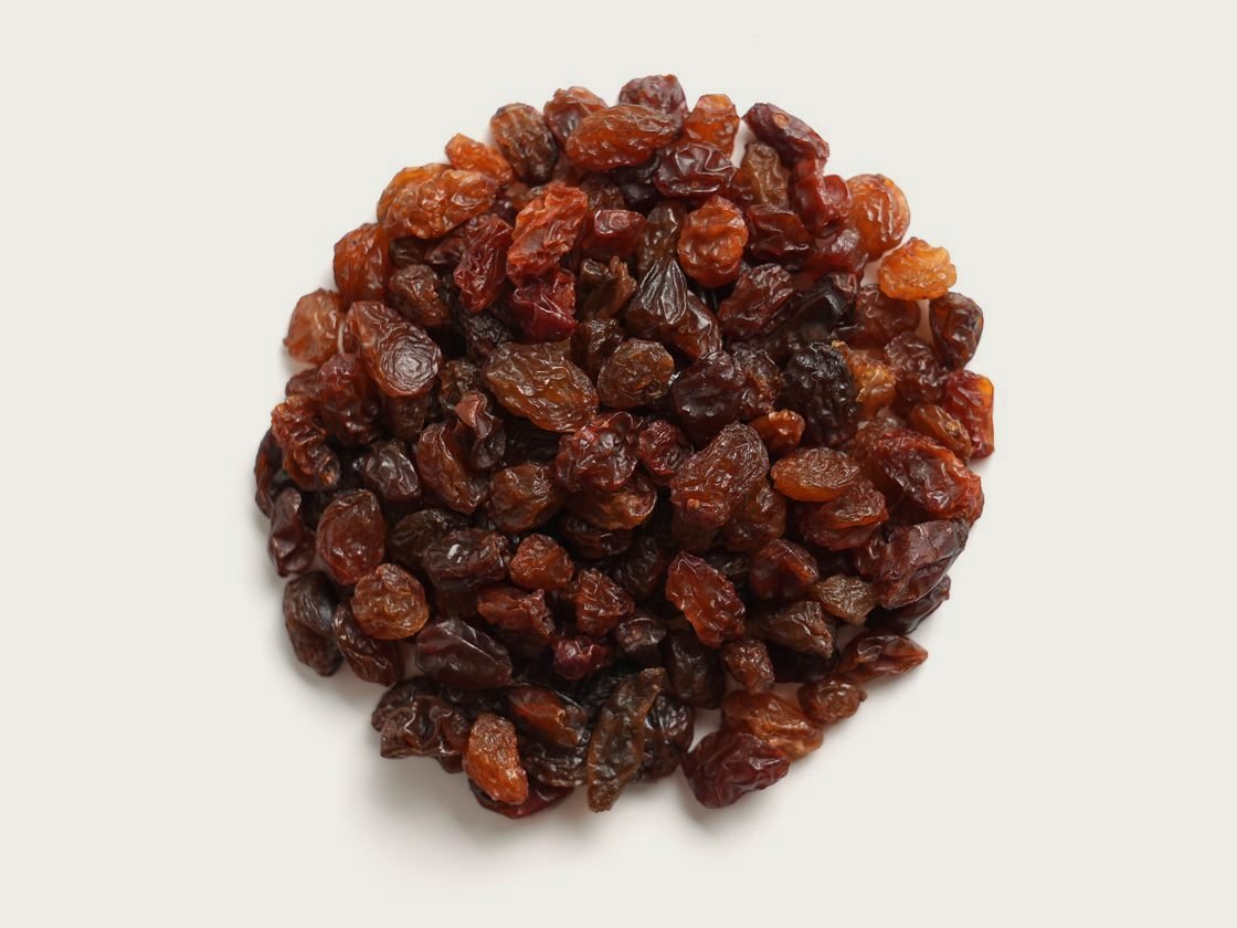 A pile of Sultana Sun-dried raisins, pale gold and evenly sized, photographed from above.