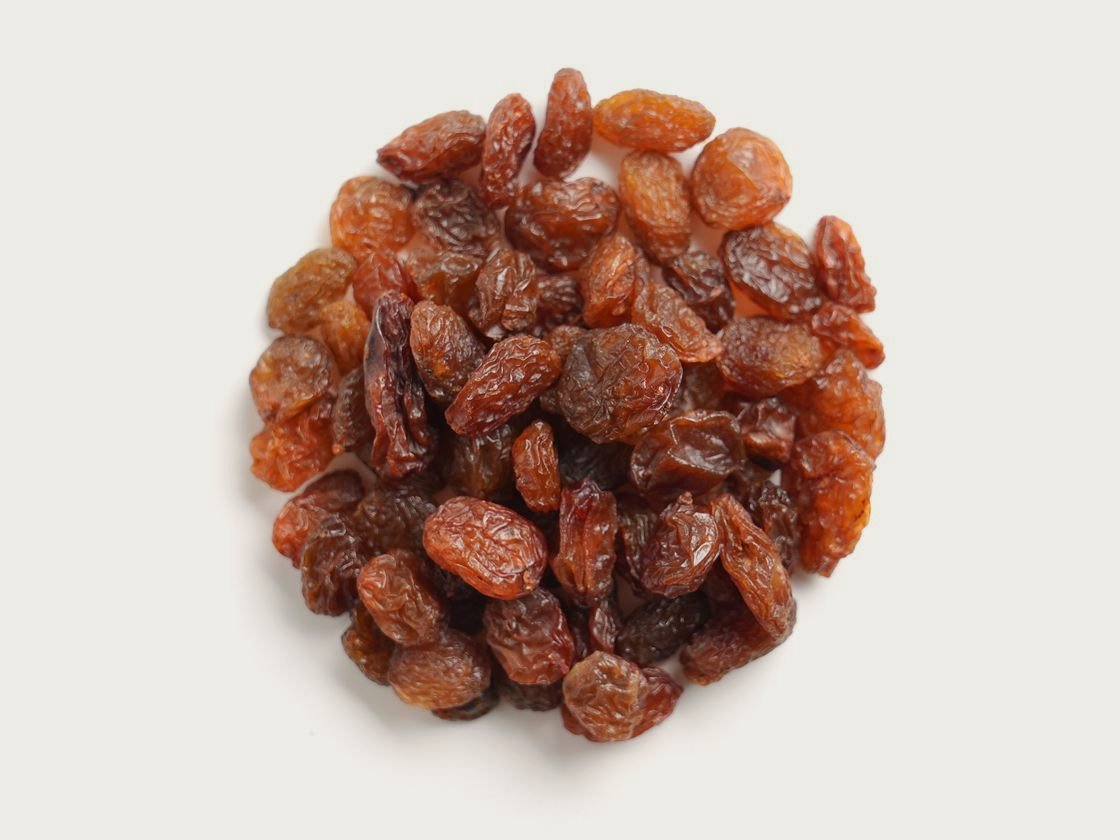 A pile of Sultana Type 9 raisins, uniform in size and colour, photographed from above.
